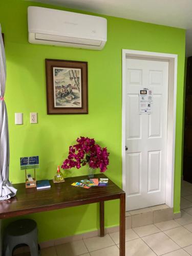 a green room with a desk and a white door at Hostal Casa Huasteca in Ciudad Valles