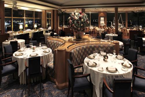 a restaurant with white tables and chairs and flowers at Hotel New Grand in Yokohama