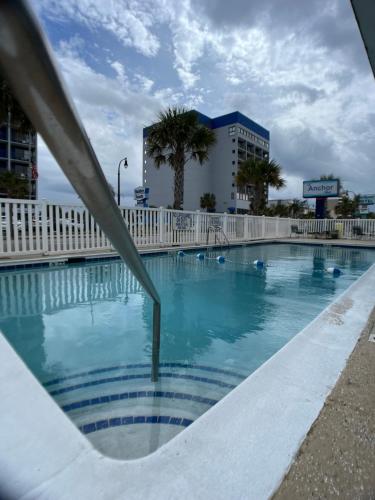 uma piscina em frente a um edifício em The anchor hotel em Myrtle Beach