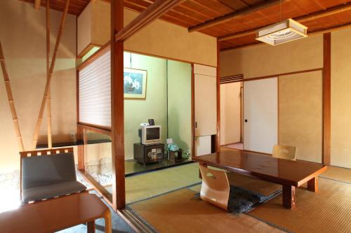a room with a desk and a tv in it at Hatsunoyu in Yamanouchi