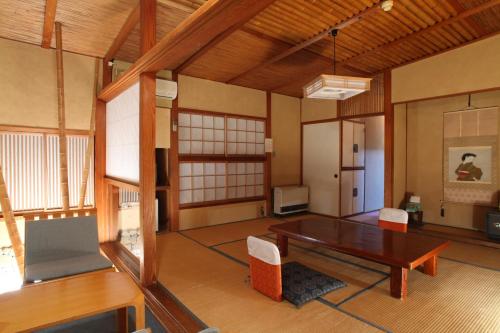 een grote kamer met een tafel en stoelen. bij Hatsunoyu in Yamanouchi