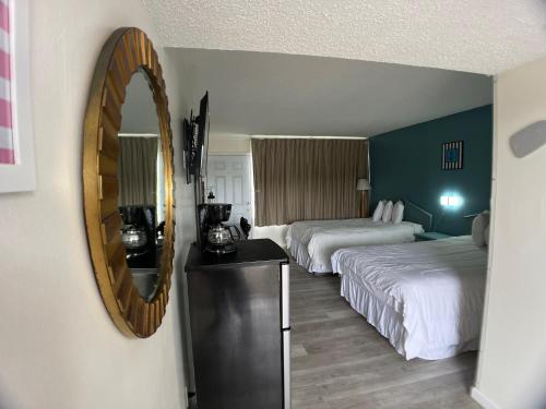 a hotel room with two beds and a mirror at The anchor hotel in Myrtle Beach