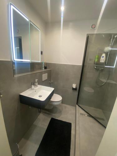 a bathroom with a sink and a toilet and a mirror at 2 Zimmer Wohnung in Krefeld City/Apartment + Netflix+Prime in Krefeld