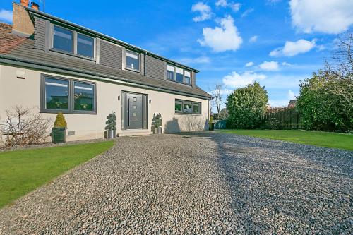 a house with a gravel driveway in front of it at Countesswells Crescent Villa ✪ Grampian Lettings Ltd in Aberdeen