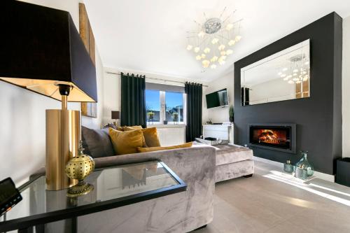 a living room with a couch and a fireplace at Countesswells Crescent Villa ✪ Grampian Lettings Ltd in Aberdeen