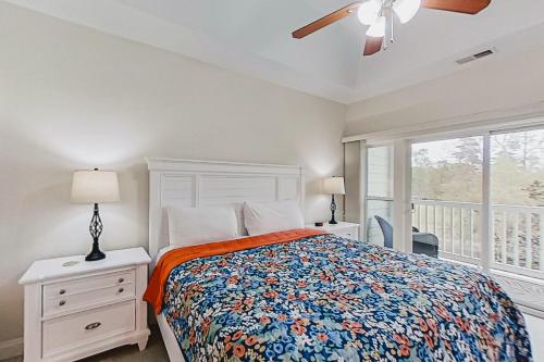 een slaapkamer met een bed, een raam en een plafondventilator bij World Tour Retreat in Myrtle Beach
