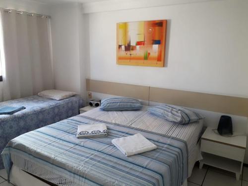 a bedroom with two beds and a picture on the wall at Apartamento Residence Praia Porto Iracema in Fortaleza