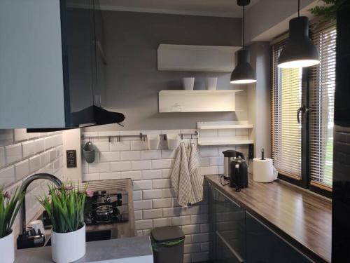 a kitchen with black and white tiles and a counter at Przytulne mieszkanko in Oświęcim