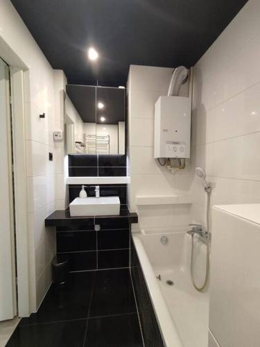 a bathroom with a sink and a mirror and a tub at Przytulne mieszkanko in Oświęcim