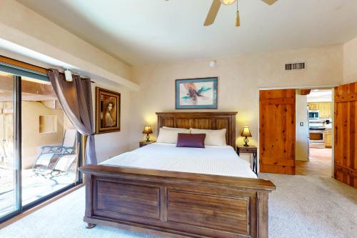 a bedroom with a wooden bed and a balcony at Saguaro Sanctuary in Tucson