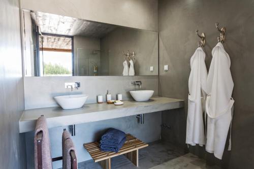 Baño con 2 lavabos y espejo en Paraiso Escondido, en São Teotónio