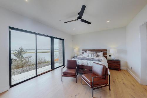 a bedroom with a bed and a large window at Modern Bayfront Memories in Coos Bay