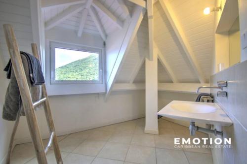 a bathroom with a sink and a window at Deux pièces sur la belle plage de Grand Case in Grand Case