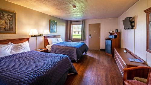 Habitación de hotel con 2 camas y TV en Magnuson Grand Harrisburg, en New Cumberland