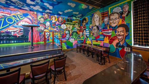 a mural in a restaurant with tables and chairs at Magnuson Grand Harrisburg in New Cumberland