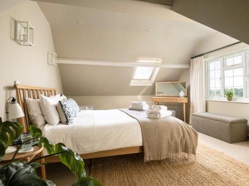 a bedroom with a large bed and a chair at Danehurst Cottage in Sway