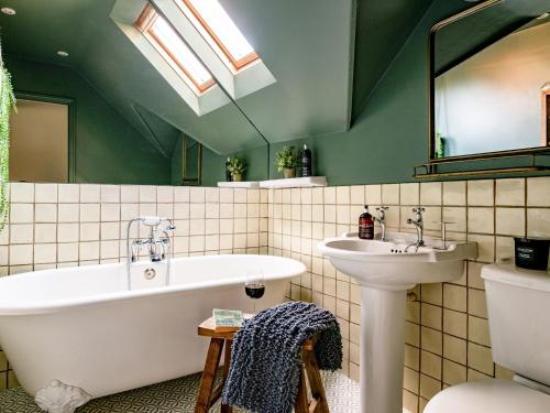 a bathroom with a bath tub and a sink at Danehurst Cottage in Sway