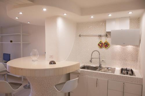 a white kitchen with a sink and a counter at Casa Vacanze L’Ulivo in Salerno