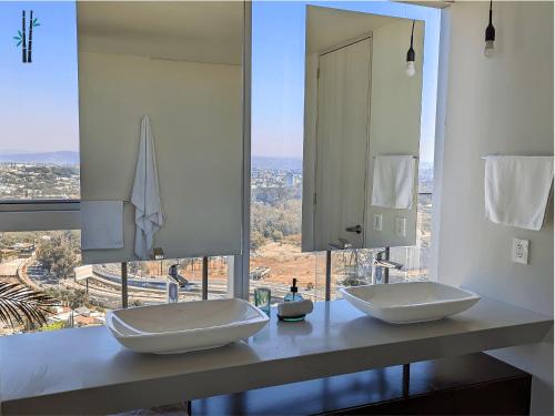 a bathroom with two sinks and a large window at Luxury Condo in Lobby33 near Andares By Bamboo in Guadalajara