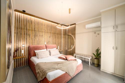 a bedroom with a bed with a pink headboard at Meltemi Beach House - a seaside Luxury maisonnette in Dhiyeliótika