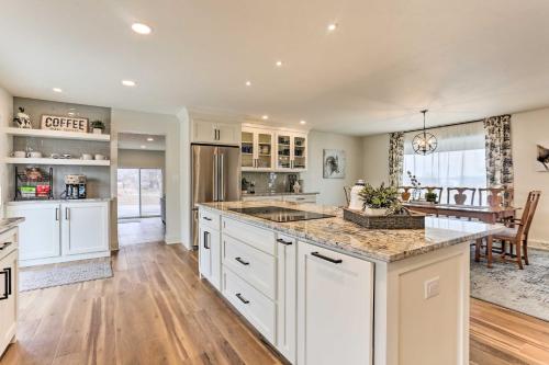 a kitchen with white cabinets and a large island at 2 Mi to Dtwn Castle Rock Home with Furnished Patio in Castle Rock