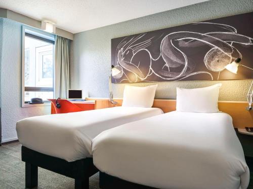 um quarto de hotel com duas camas e um quadro na parede em ibis Paris La Villette Cité des Sciences 19ème em Paris
