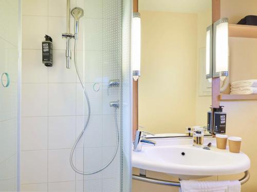 La salle de bains est pourvue d'une douche et d'un lavabo. dans l'établissement ibis Paris La Villette Cité des Sciences 19ème, à Paris