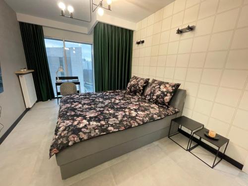 een slaapkamer met een bed met een bloemenbed bij Towarowa Milionowa 39 Check-in 24 H in Poznań