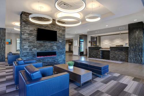 a lobby with blue chairs and a fireplace at Days Inn & Suites by Wyndham Warman in Warman