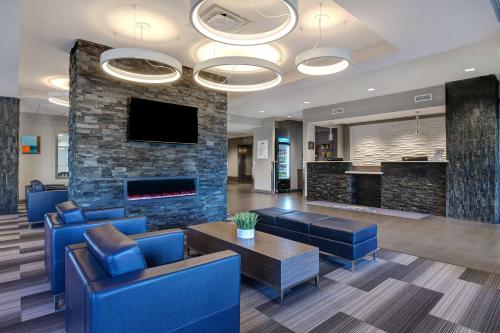 a lobby with blue chairs and a fireplace at Days Inn & Suites by Wyndham Warman Legends Centre in Warman