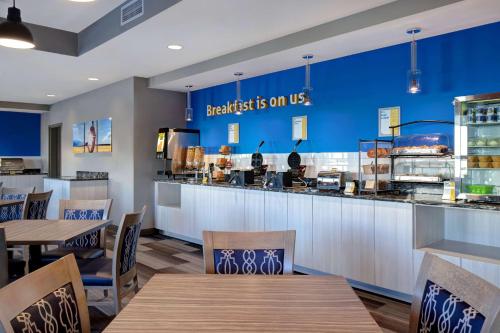 a restaurant with a counter with tables and chairs at Days Inn & Suites by Wyndham Warman in Warman