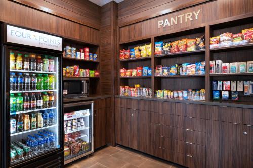 a pantry with many different types of food and drinks at Four Points by Sheraton Fort Worth North in Fort Worth