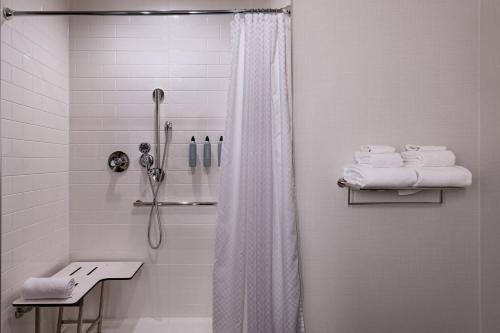 a white bathroom with a shower and a sink at Four Points by Sheraton Fort Worth North in Fort Worth