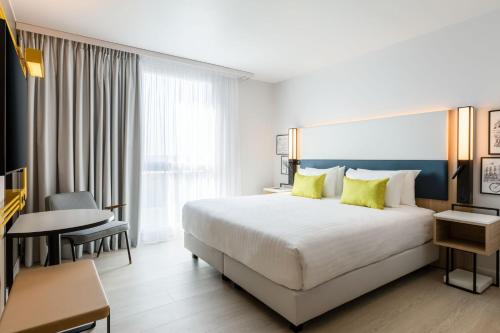 um quarto de hotel com uma cama grande e uma mesa em Courtyard by Marriott Paris Creteil em Créteil