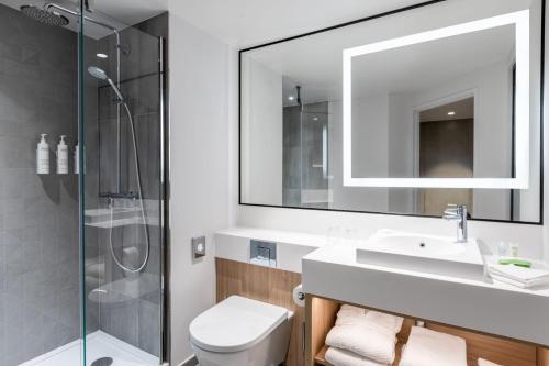 La salle de bains est pourvue de toilettes, d'un lavabo et d'une douche. dans l'établissement Courtyard by Marriott Paris Creteil, à Créteil