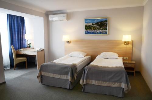 Habitación de hotel con 2 camas y escritorio en Atlantica (ex-Optima) Sevastopol, en Sevastopol