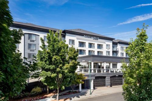 an exterior view of a hotel with trees at Courtyard by Marriott Portland North in Portland