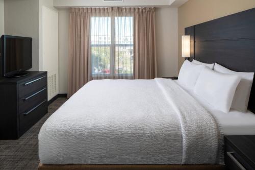 Pokój hotelowy z dużym łóżkiem i telewizorem w obiekcie Residence Inn by Marriott Cape Canaveral Cocoa Beach w mieście Cape Canaveral