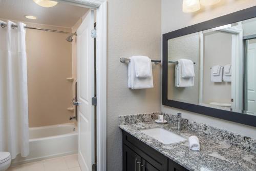 a bathroom with a sink and a mirror at Residence Inn by Marriott Cape Canaveral Cocoa Beach in Cape Canaveral