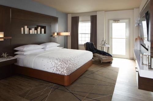 1 dormitorio con 1 cama grande y 1 silla en The Del Monte Lodge Renaissance Rochester Hotel & Spa, en Rochester