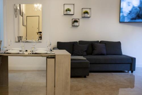uma sala de estar com um sofá e uma mesa em San Babila - Luxury Milanese Apartment em Milão