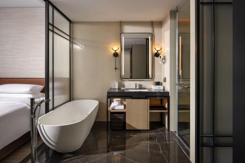La salle de bains de l'hôtel est pourvue d'une baignoire et d'un lavabo. dans l'établissement Sheraton Ningbo Xiangshan Resort, à Xiangshan