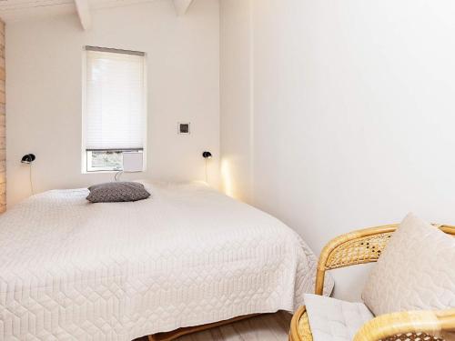 een slaapkamer met een wit bed en een raam bij Three-Bedroom Holiday home in Løkken 78 in Løkken