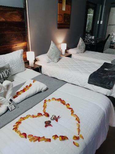 a hotel room with two beds with a heart on them at Ay Jay's Guesthouse in Bloemfontein