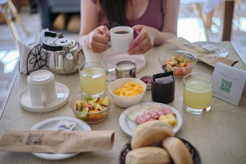 a woman sitting at a table with breakfast foods and drinks at Hotel El Tesoro de Elqui in Pisco Elqui