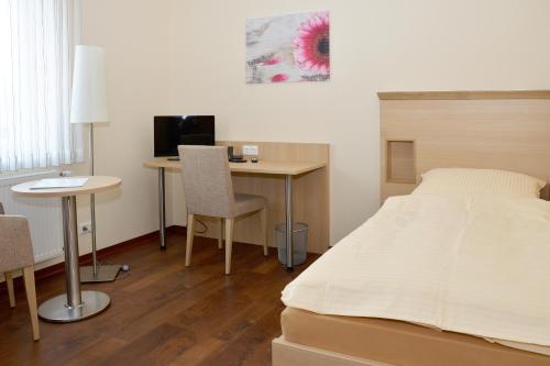 1 dormitorio con 1 cama y escritorio con ordenador en Gasthaus-Witte, en Wallenhorst