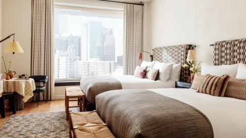 a hotel room with two beds and a window at Downtown Los Angeles Proper Hotel, a Member of Design Hotels in Los Angeles