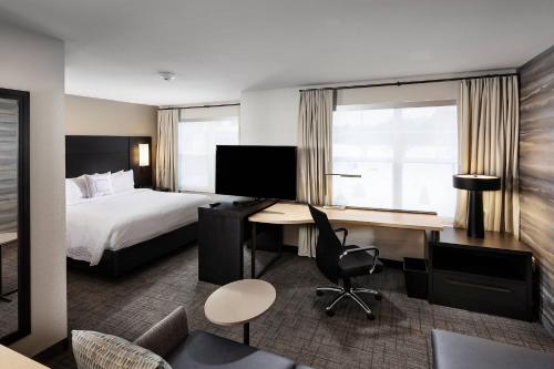 a hotel room with a bed and a desk at Residence Inn by Marriott Milwaukee Brookfield in Brookfield