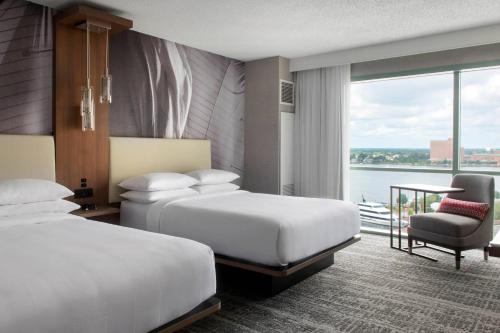 una habitación de hotel con 2 camas y una silla en Norfolk Waterside Marriott en Norfolk