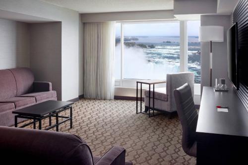 a living room with a couch and a table and a window at Niagara Falls Marriott Fallsview Hotel & Spa in Niagara Falls